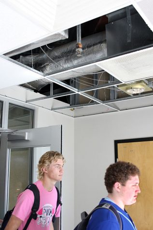 Senior Hunter Paxton and junior Shane Howell walk out the library entrance doors despite the gaping hole in the ceiling. 