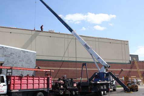 Workers continue to work on the roof during the school day.