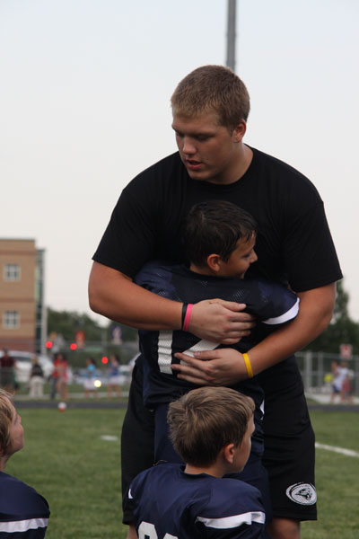 Senior Zach Callahan gives a hug to a future Jaguar football player. Photo by Emily Johnson