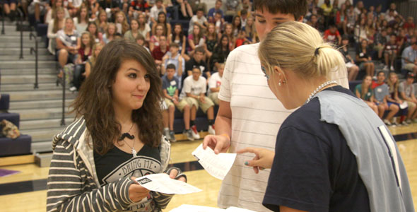 Student council sponsor Jessica DeWild hands out gift cards as prizes during freshman orientation.