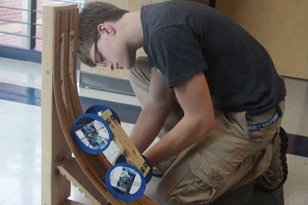 Junior Tyler Hinnen test runs his gravity vehicle during a Science Olympiad meeting on Thursday, Feb. 8. “You have a car powered entirely by gravity,” Hinnen said. “It is supposed to go a preset distance that [the judges] tell you, which is somewhere between five to ten meters.” Hinnen says that the vehicle runs fairly well.  