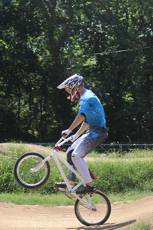 Senior Josh Thomason pops a wheelie while practicing riding his BMX bike on Sunday, Sept. 8 in Topeka. He is preparing to compete in the Grand Nationals.