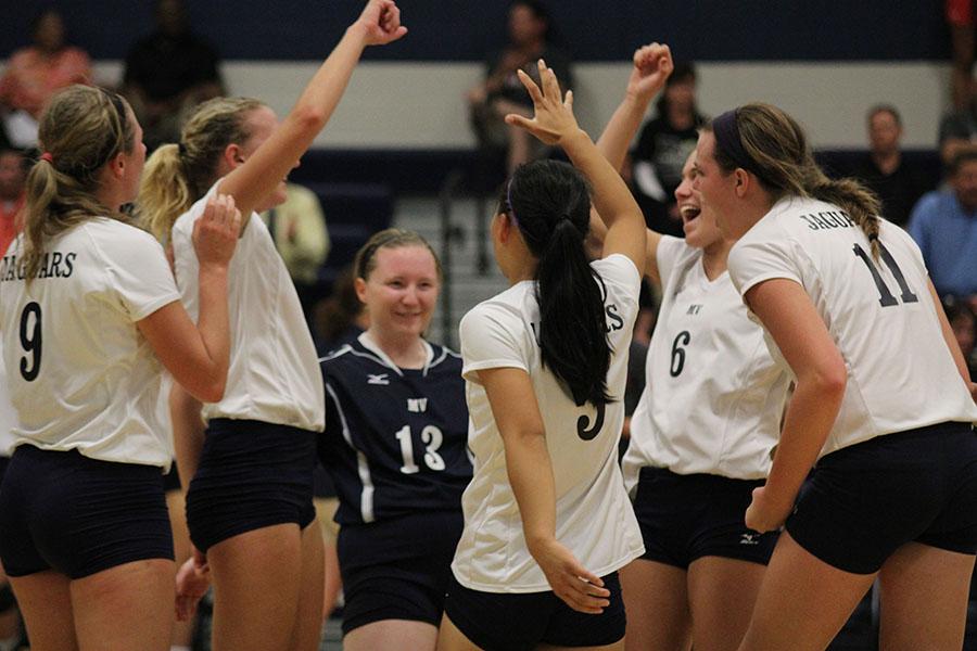 Members of the volleyball team celebrate a point in the match against Blue Valley on Thursday, Sept. 19. The team defeated Blue Valley and lost to Blue Valley West.
