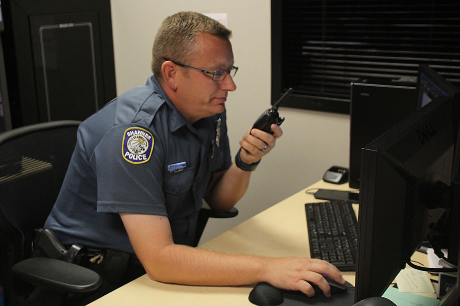 Speaking to an administrator through his radio, school resource officer Mo Loridon watches surveillance video on Friday, Sept. 20.  Preparation is literally just all about education, Loridon said. I now have to re-educate teachers and staff members on how to survive if something like that happens.