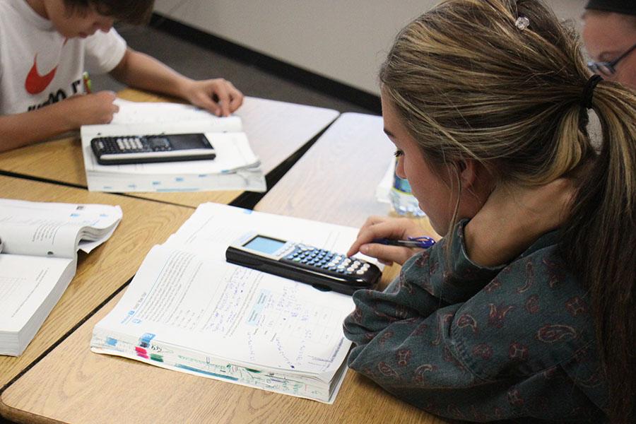 Freshman Alea Ashford works out a problem in her Integrated Math I textbook as opposed to on a separate sheet of paper, a new way of learning implemented by Common Core.  “Common Core is not as fast-paced as the previous curriculum and it is not as in-depth” Ashford said.