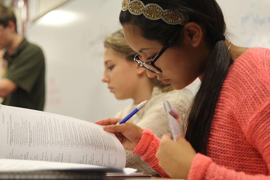 To prepare for the meet against Spring Hill High School on Saturday, Nov. 9, freshman Mariana Cruz looks over her notes while another classmate makes an opposing statement.
