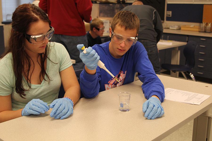 During AP Biology, senior Jason Biesma and senior Carly Eaton practice using a pipette for a lab on Tuesday, Nov. 5. 