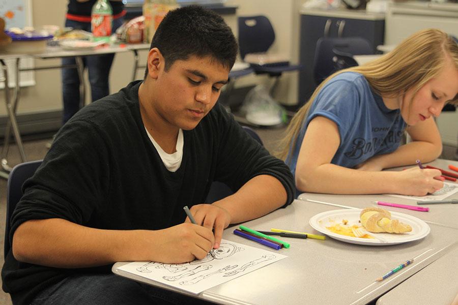 Sophomore Thomas Franco colors a skeleton after eating authentic mexican food for Dia de los Muertos on Thursday, Nov. 7.