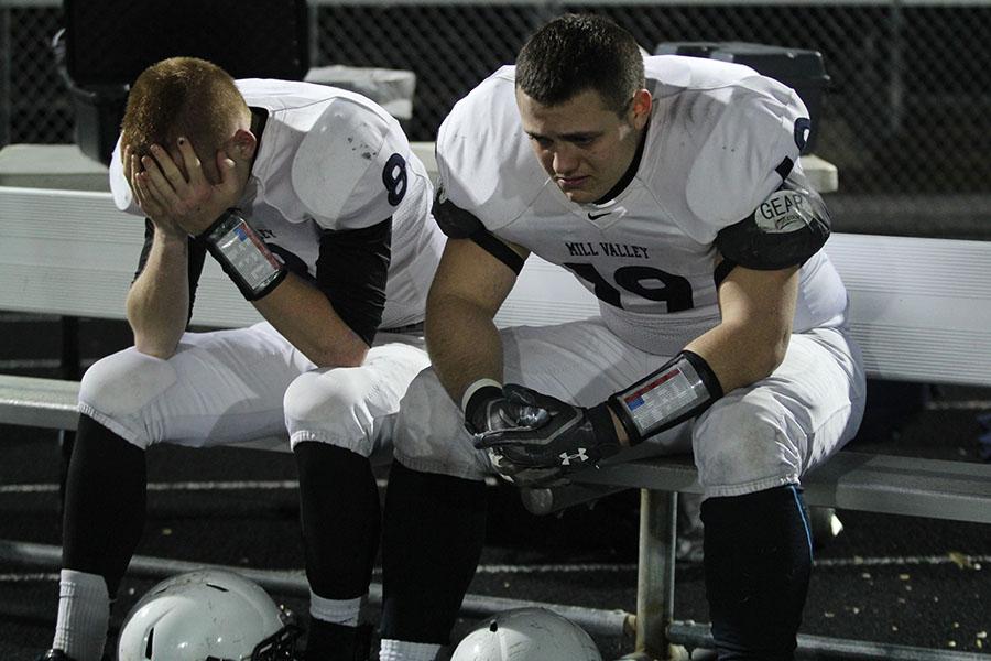 Senior tight end Dylan Cole and junior quarterback Ty Bruce sit on the sideline as the last game of the 2013 season comes to an end. The Jaguars lost 38-0 to Blue Valley High School.