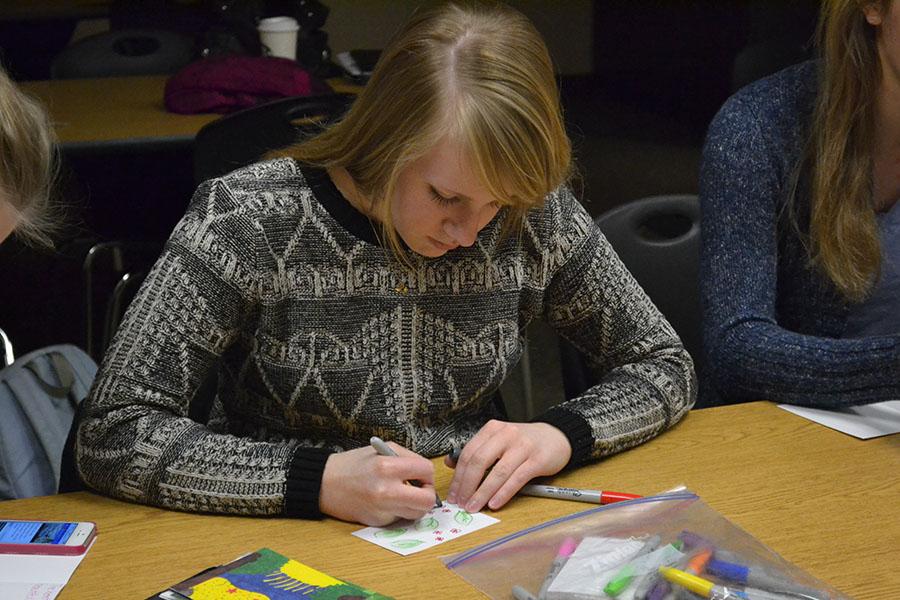 While attending a Girl Scouts meeting on Tuesday, Jan. 21, junior Kate Schau decorates a card. She and other Girl Scouts wrote positive notes on cards and plan on randomly handing them out to people they meet.