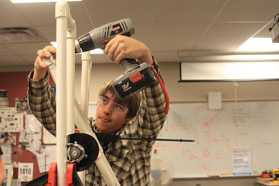 Senior Brandon Heinson helps prepare part of the robot by attaching an elbow piece to the arm of the robot for the Robotics team on Saturday, Jan. 18.