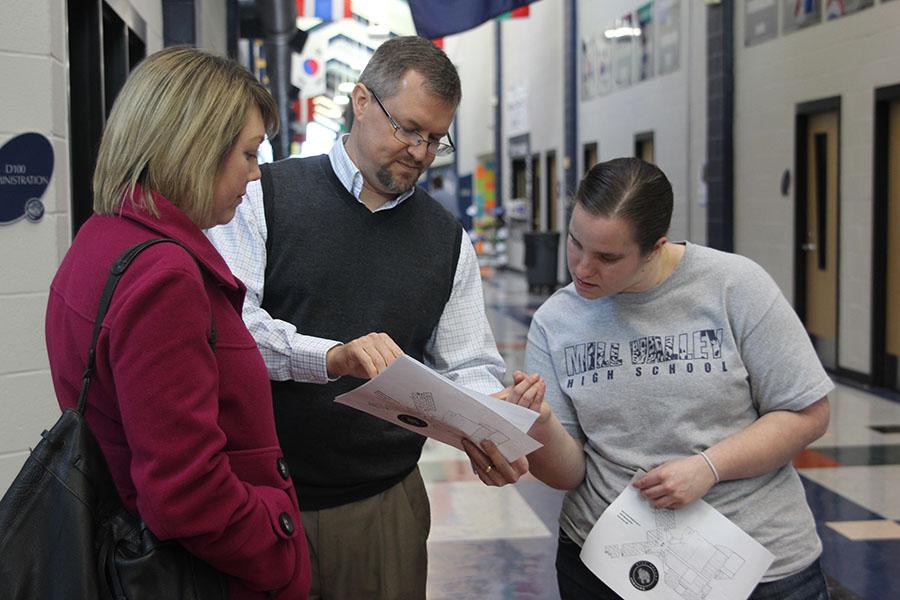 As a student ambassador, junior Abigail Kelm helps parents find classrooms for conferences on Thursday, Feb. 13.