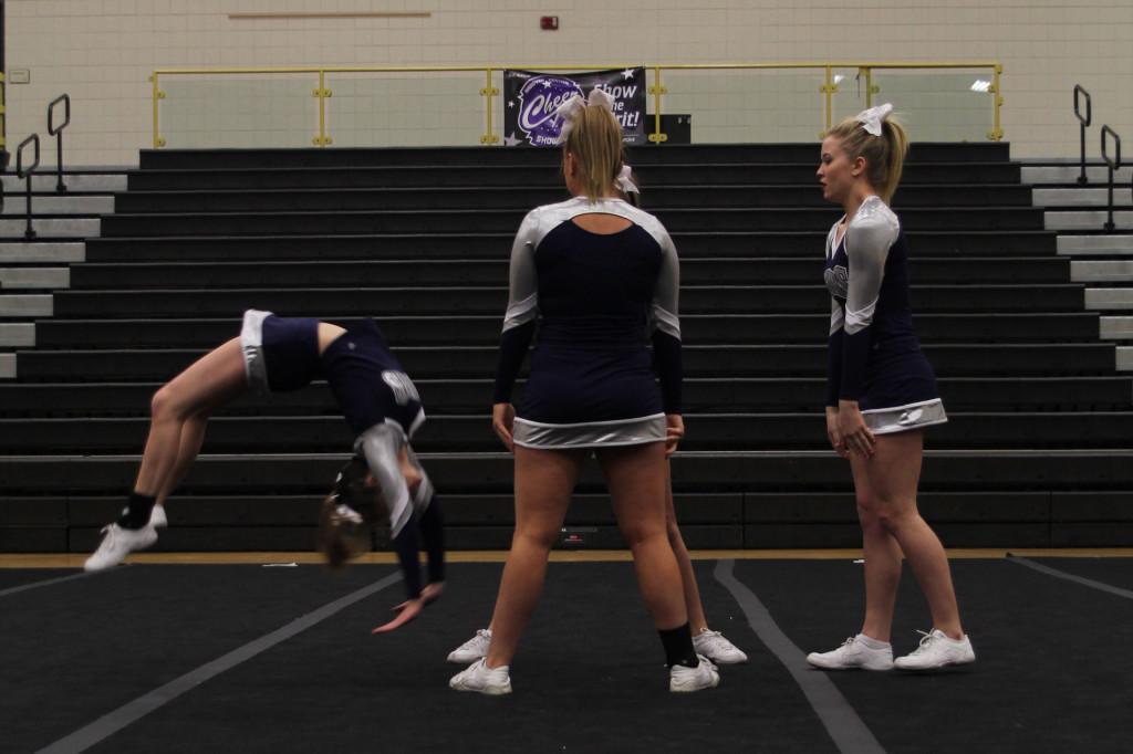 Senior Taylor Schmidt does a back handspring into the arms of her bases during her individual stunt sequence. The individual group received a one rating at the Andover Central Showcase on saturday, Feb. 15. 