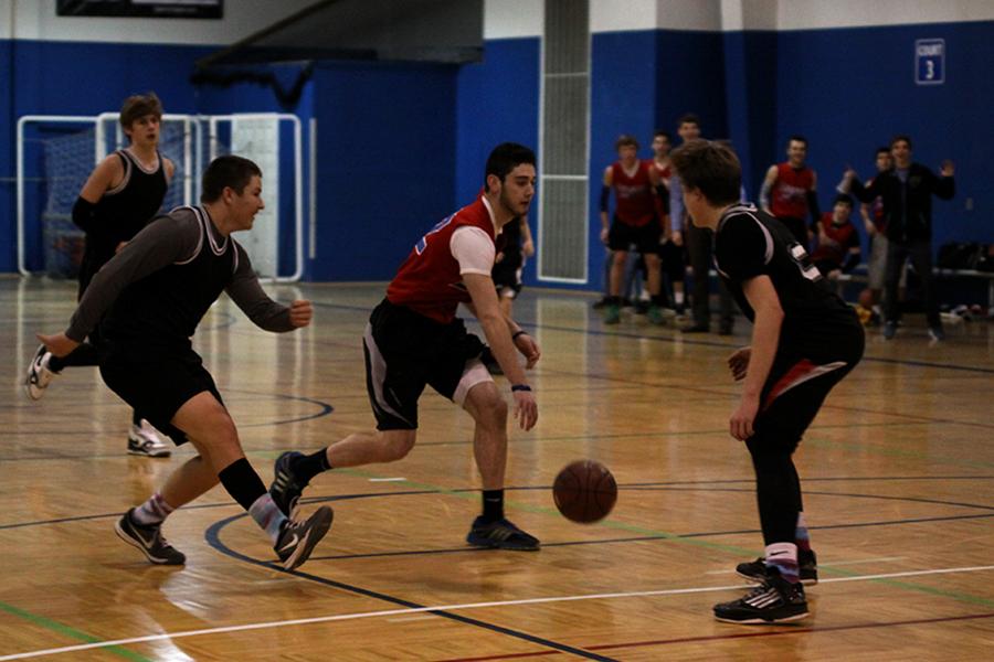 Sophomore Joe Wilson dribbles down the court while sophomores Brock Miles and Tyler Shurley defend during a recreation basketball game at Okun Fieldhouse on Thursday, Jan. 30.