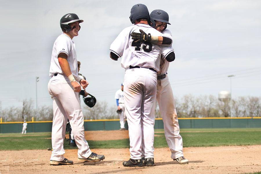 Seniors Nick Wilson, Micah Clarke, and Coltyn Gatton celebrate Wilsons grand slam at a game against Garder-Edgerton on Saturday, April 25. The Jaguars fell short to the Blazers placing second in the USD232 Invitational with a final score of 12-13. 