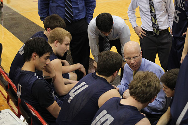Former head boys basketball coach Justin Bogart discusses strategy with his players during a timeout on Friday, March 7.