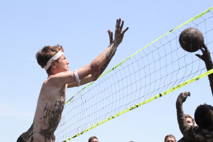 Blocking a mud covered volleyball on Saturday, May 10, senior Jason Biesma participates in the annual Mayhem Week mud volleyball game.