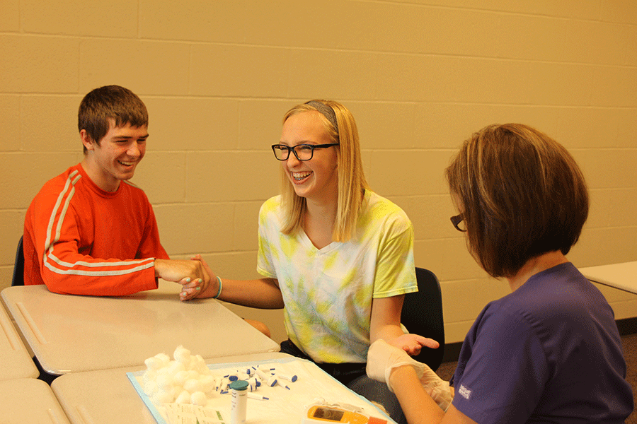 During Health class sophomore Erika Marsh nervously get her cholesterol tested  while sophomore Seth Wagner holds her hand.