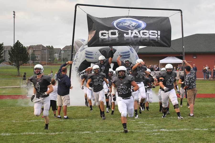 The football team storms the field as they get ready to take on the St. Thomas Aquinas Saints on Friday, Sept. 5