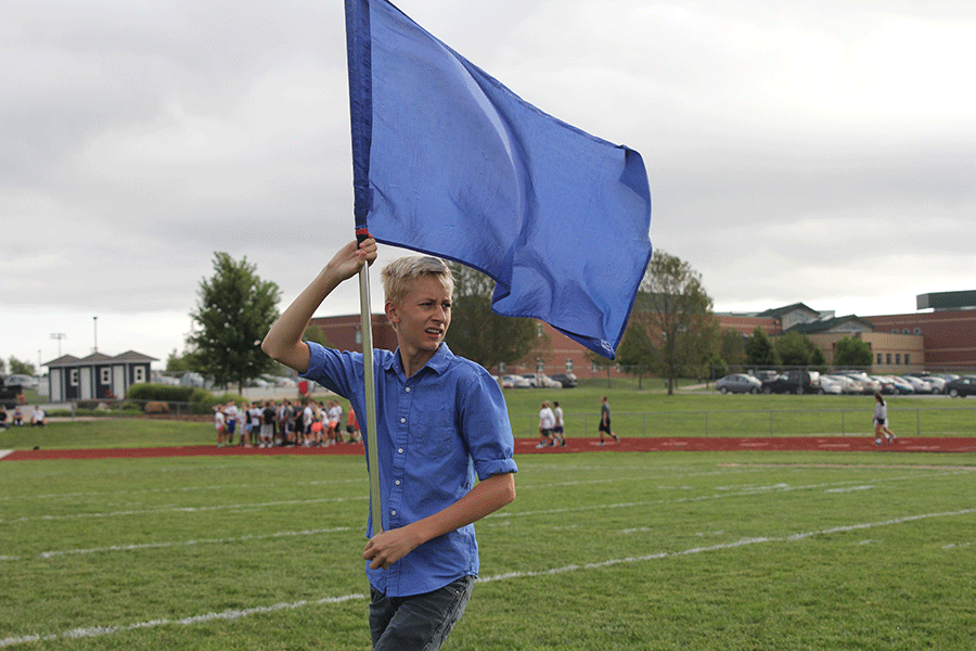 Flag in hand, sophomore Knowle Julander practices color guard on Friday, Sept. 5.