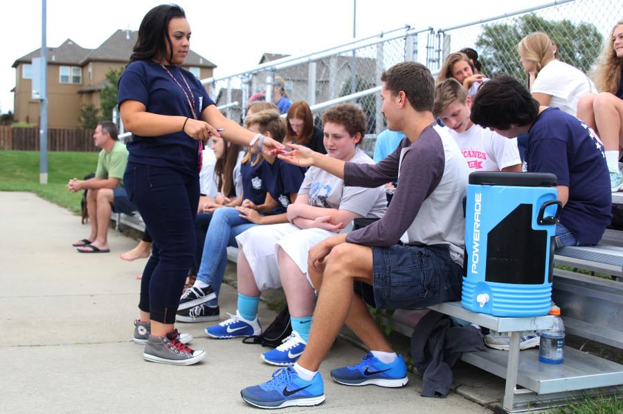 In order to receive class cup points for her class, junior Taylor Pullen hands a ticket to Student Leadership member senior Cody Deas. "We pass out and collect tickets for class cup. [Class cup] promotes school spirit," Deas said.