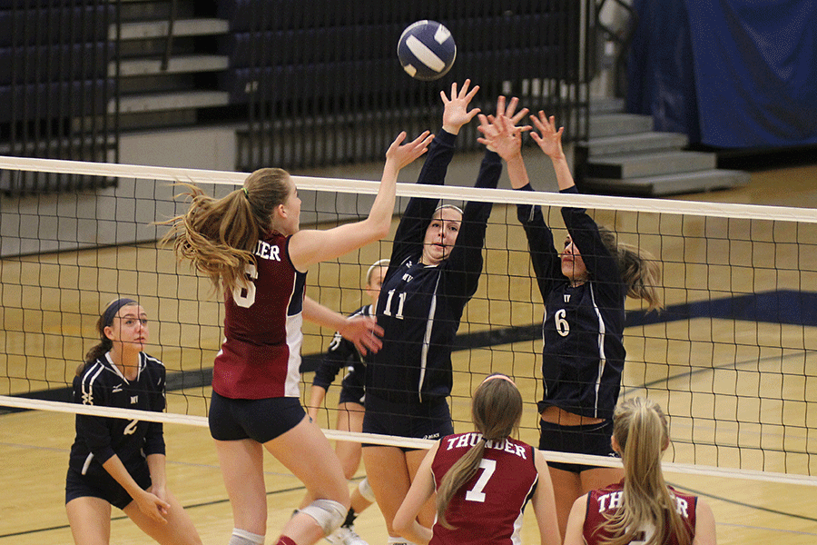 Freshman Izzy Hellon and senior Maddie Little go up for a block on Thursday, Sept. 18.