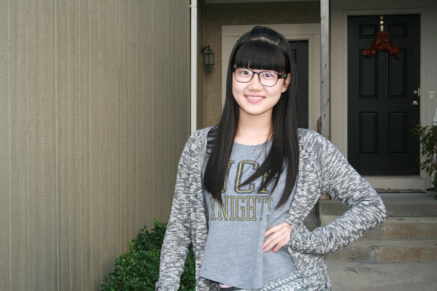 Standing in front of her host familys house on Tuesday, Sept. 30, senior Amber Zou spends a year of schooling in America through a foreign exchange student program. 