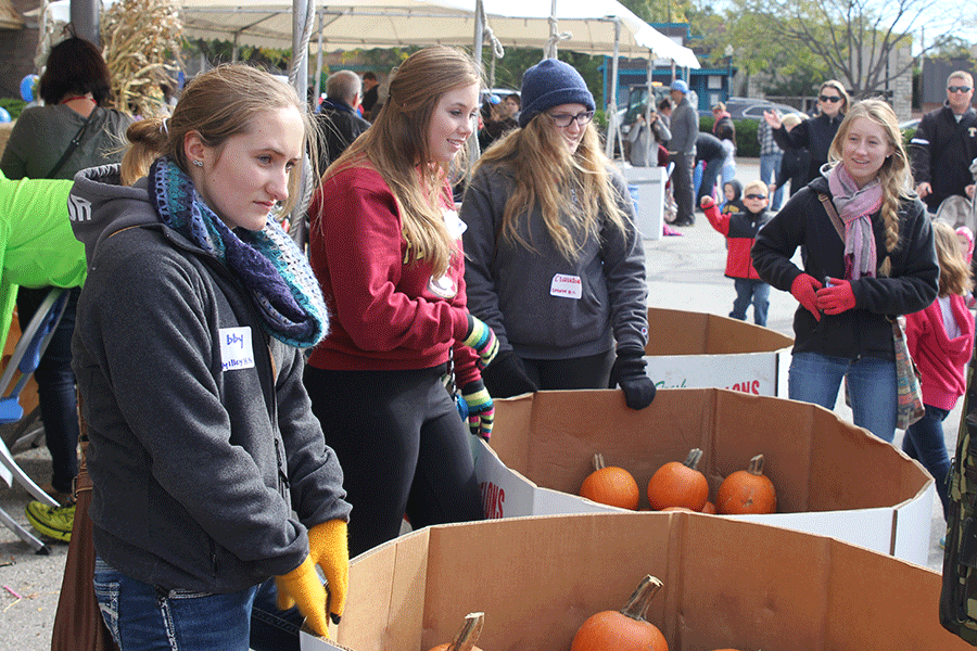 For her Community Service class, senior Abby Taylor volunteers to hand out pumpkins to kids on Saturday Oct. 4. “[I wanted to take the class because] I had friends that had taken it who really enjoyed it,” Taylor said. 