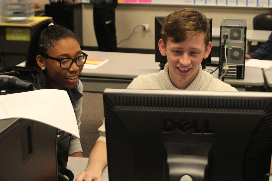 In preparation for the new cookies for the Catty Shack, junior Hawkeye Mitchell and senior Lordis Payne work on an advertisement in Advanced Marketing on Tuesday, Dec. 2. The students in Advanced Marketing participate in DECA as well as work in the Catty Shack.