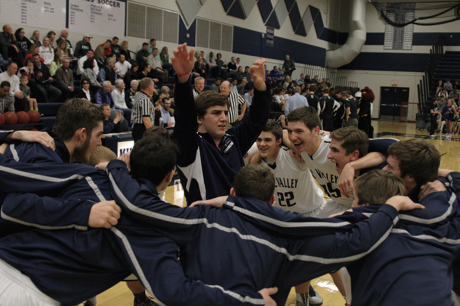 In order to get his team excited, junior Logan Koch dances in the middle of the huddle before the start of the basketball game against Lawrence Free State Friday, Dec. 13. The Jaguars fell to the Fire Birds, 59-41. 