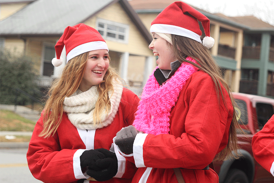 Singing Christmas carols, juniors Abbie Hughes and Sydney Hansen entertain the Santa Dash runners on Sat. December 6.