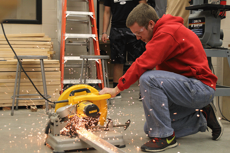 Sophomore Bo Wells cuts a piece of metal pipe on Wednesday, Dec. 3 in Mr. Vomhofs Blue 1 Residential Carpentry class. [Taking the class enables someone] to find a solution to a problem in your house, Wells said.