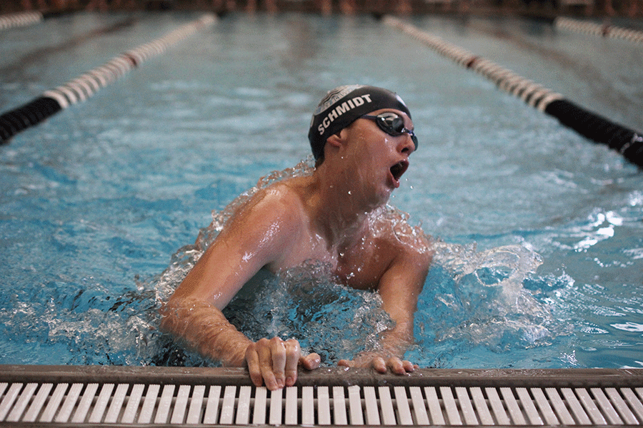 Junior Logan Schmidt performs a turnaround during the boys swim meet at Blue Valley Southwest on Saturday, Jan. 24.