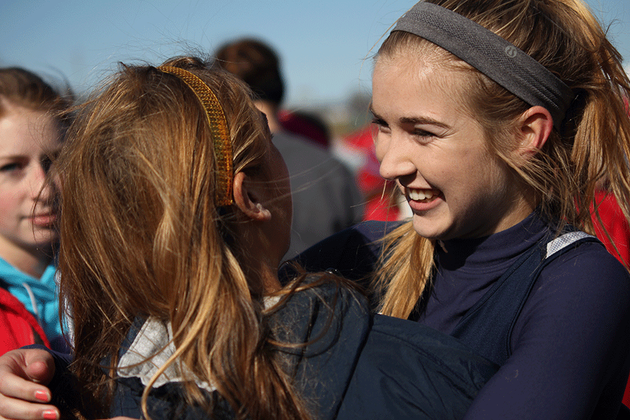 Junior Amber Akin embraces a friend after finishing in 16th place at the state cross country meet on Friday, Oct. 31 at Rim Rock Farm. 
