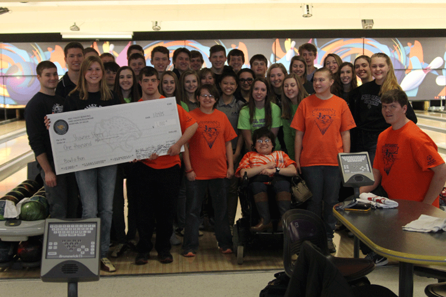 The bowling team presents the $1,000 check to the special olympics team, Shawnee Storm.