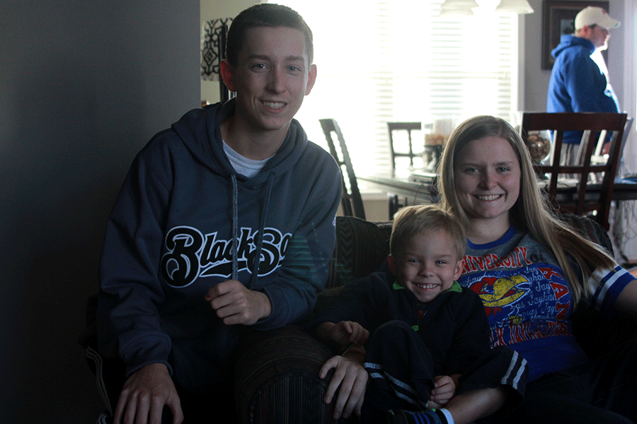 Freshmen twins Cole and Grace Abram smile for a photo with their adopted brother, and cousin, Peyton Abram, on Friday, Jan. 9.