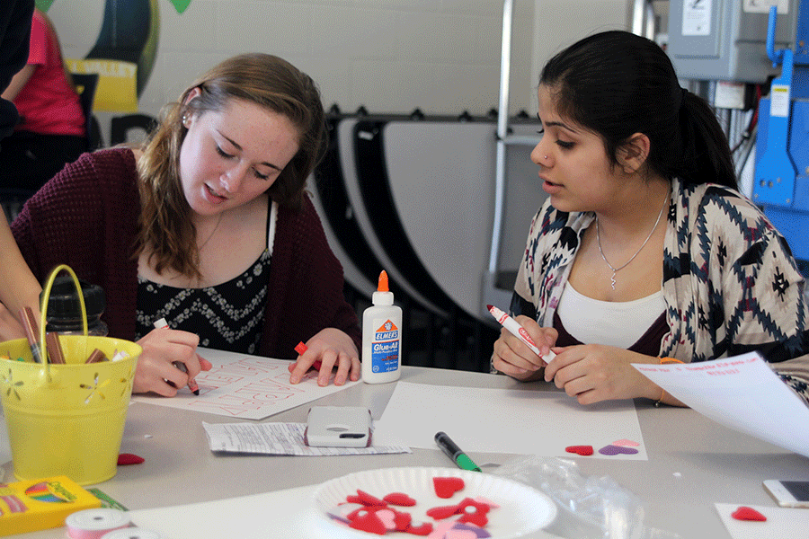 Sophomores Elaina Bartlow and Harman Kaur create Valentines Day posters on Friday, Jan. 23.