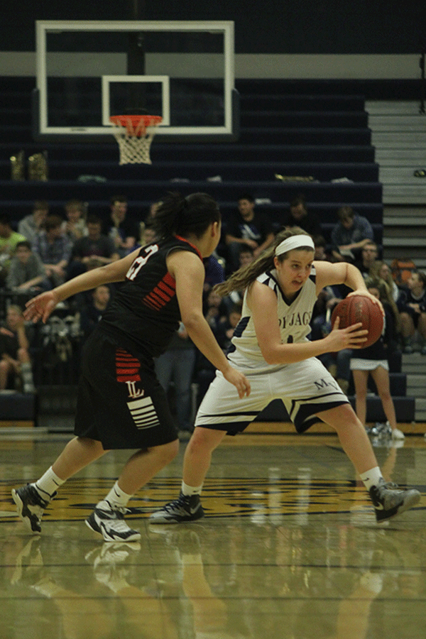 Senior Lacie Myers guards the ball from her opponent. 