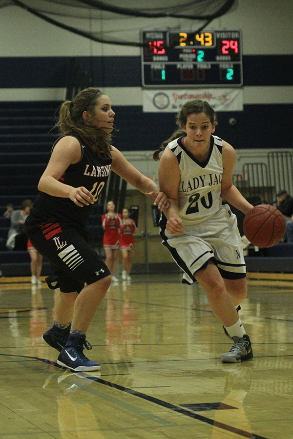 Senior Lexie Myers dribbles the ball while pushing her opponent aside.