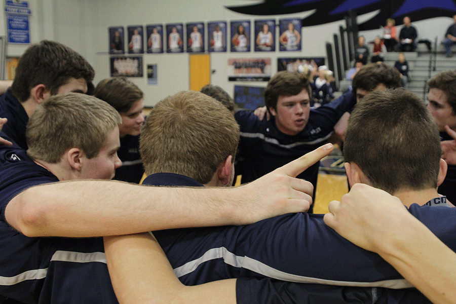 Before the start of the game against Olathe Northwest, junior Tyler Grauer holds up the number one while in a huddle on Friday, Jan. 30. The Jaguars defeated the Ravens, 54-47.