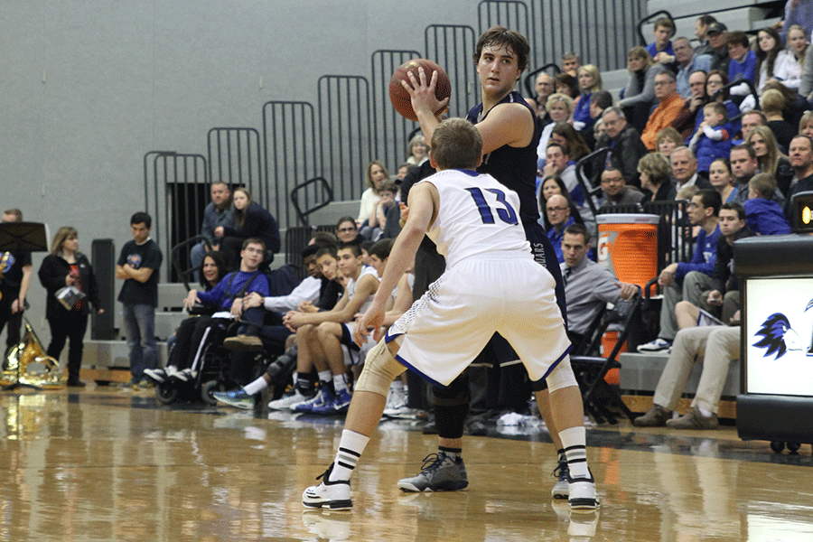 Junior Logan Koch looks for an open teammate during the basketball game against Olathe Northwest on Friday, Jan. 30.