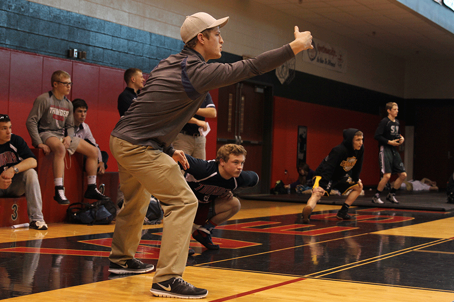 Assistant coach Bo Pursel coaches a wrestler during his match on Saturday, Feb. 21.