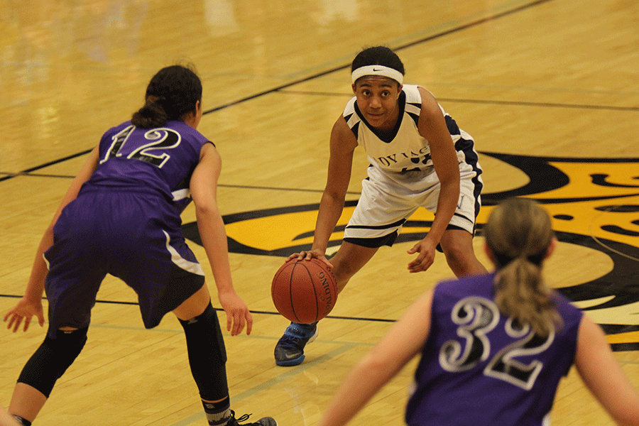 Dribbling the ball, senior Jabria Leggett looking for an open teammate.