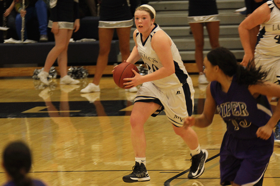 After rebounding, junior Catie Kaifes dribbles the ball down the court.