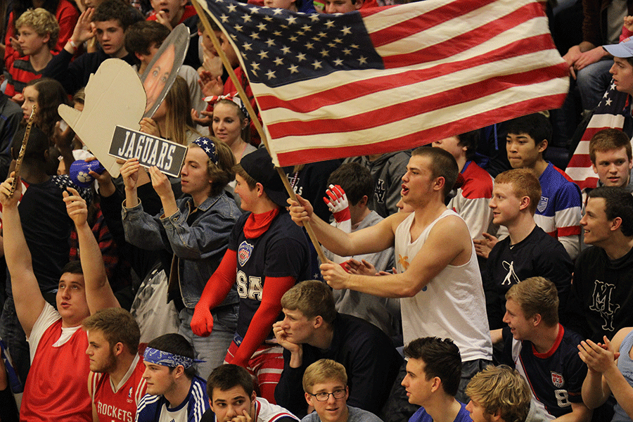 Waving an American flag for USA Night, junior Grant Warford cheers on the girls basketball team.