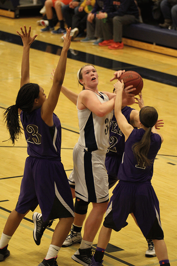 Trying to make a shot, junior Catie Kaifes is blocked by the other team.
