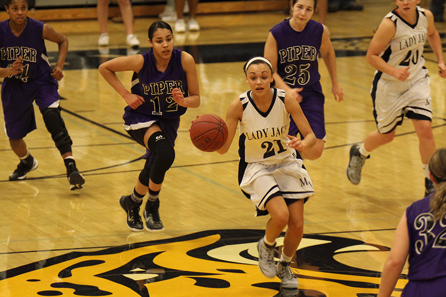 Dribbling down the court senior Whitney Haslett goes toward the net.