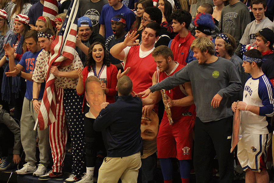 Senior Evan Applegate gives associate principal David Ewers a high-five after a basket is made.