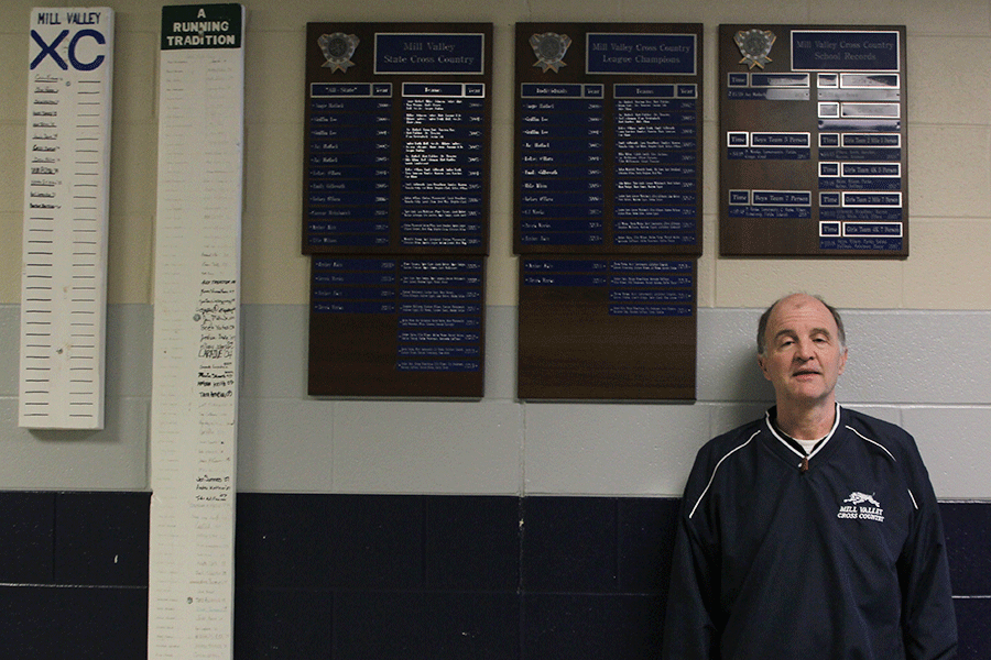 Cross Country coach Mark Chipman stands with over 70 awards won by the team on Tuesday Feb. 10.