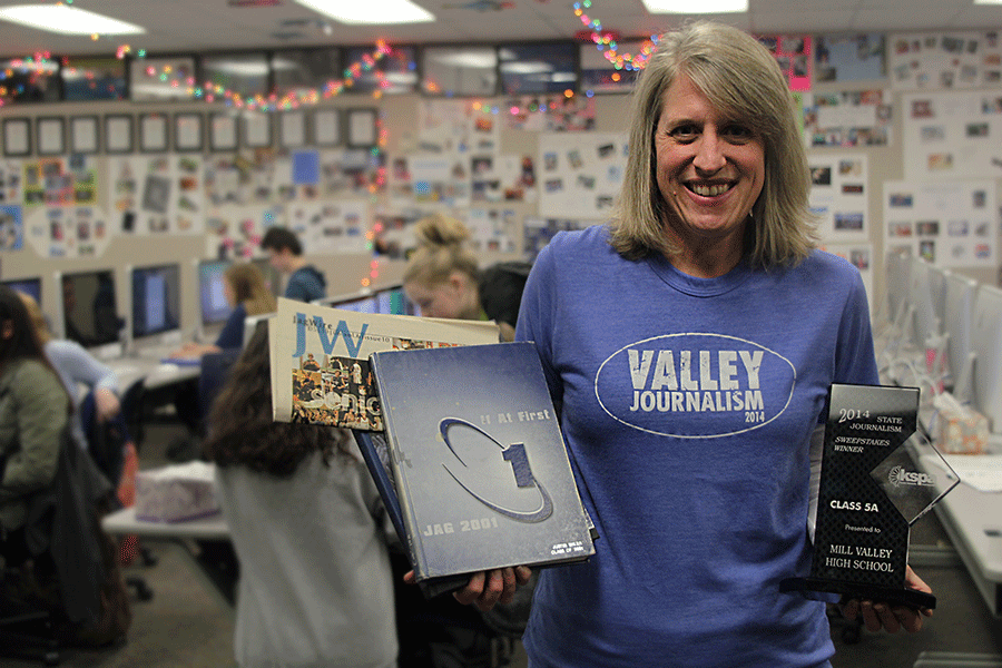 Journalism adviser Kathy Habiger holds various awards and publications that represent the success of the journalism department on Monday, Feb. 9.